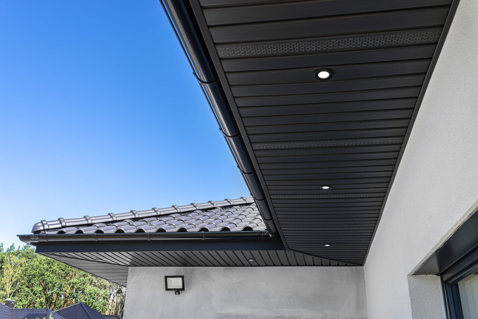 A modern graphite herringbone roof lining is attached to the trusses, visible turned on LED lights.